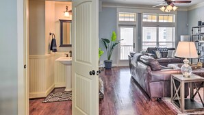 A living room with a leather sofa, a coffee table, and a lamp. There is a door leading to a bathroom with a sink and mirror. - Corpus Christi Home w/ Golf Cart: Walk to Beach! (Corpus Christi)