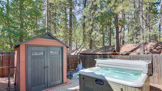 A hot tub in a backyard with a wooden deck, a shed, and a wooden fence. - 1 Mi to Snow Summit: Big Bear Lake Cabin! (Big Bear Lake)