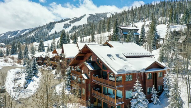 A wooden lodge with multiple balconies and large windows, surrounded by snow-covered trees and mountains. - Slopeside Sanctuary - Penthouse < 1 Mi to Lifts! (Winter Park)