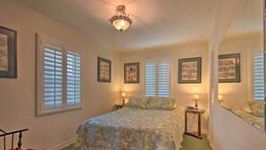 A bedroom with a large bed, two bedside tables with lamps, and a ceiling light fixture. - Avalon Escape: Everything Within Walking Distance! (Avalon)