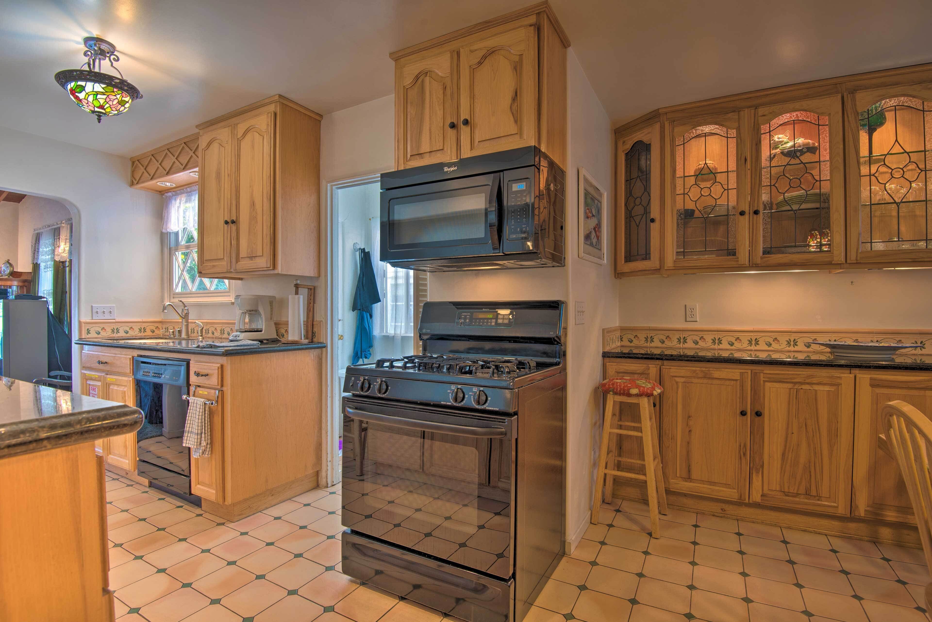 A kitchen with wooden cabinets, a stainless steel stove, a microwave, and a dishwasher.