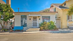 A small, single-story house with a front porch, a blue bench, and a small garden area. - Avalon Escape: Everything Within Walking Distance! (Avalon)