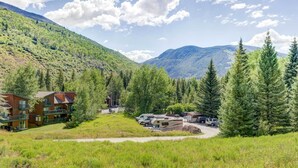 A lodge with multiple buildings, a parking area, and a mountainous backdrop.