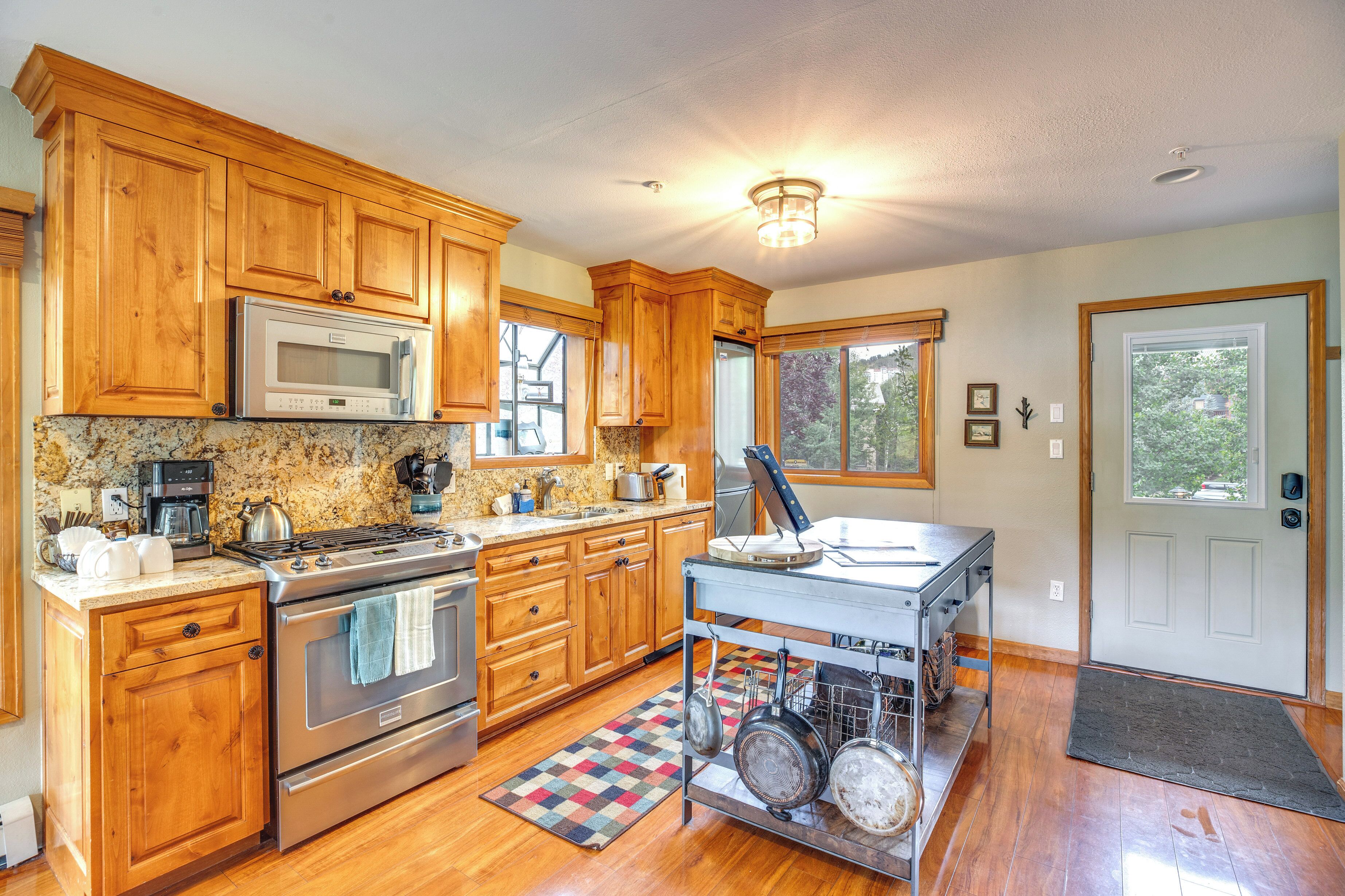 A kitchen with wooden cabinets, stainless steel appliances, and a granite countertop.