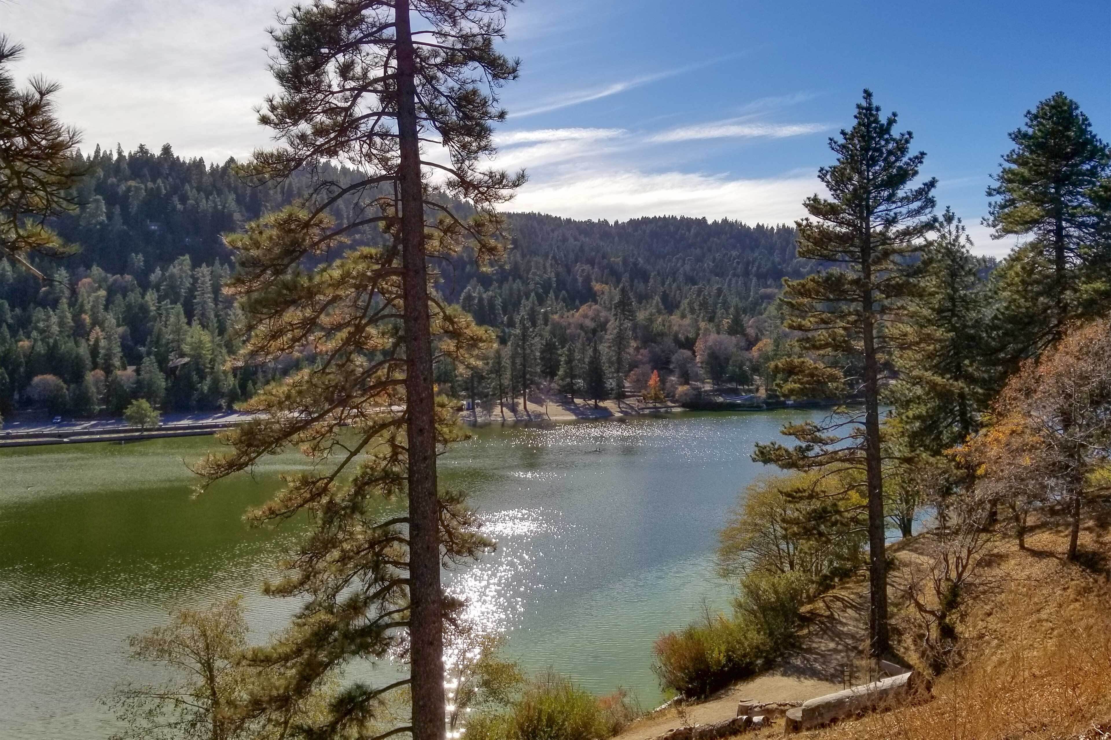 Un lac entouré d’arbres et de collines.