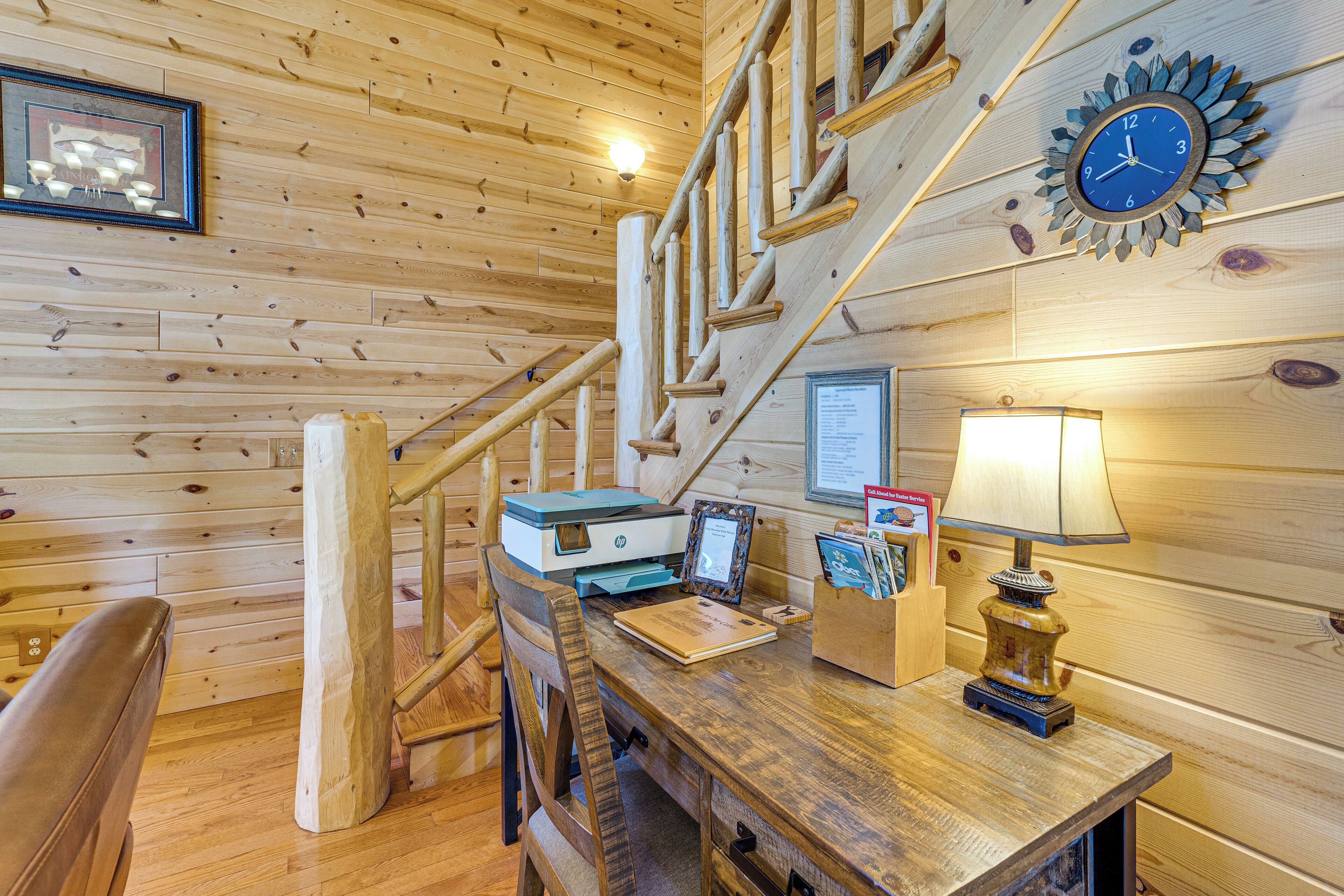 A wooden interior with a desk, chair, lamp, and a clock on the wall.