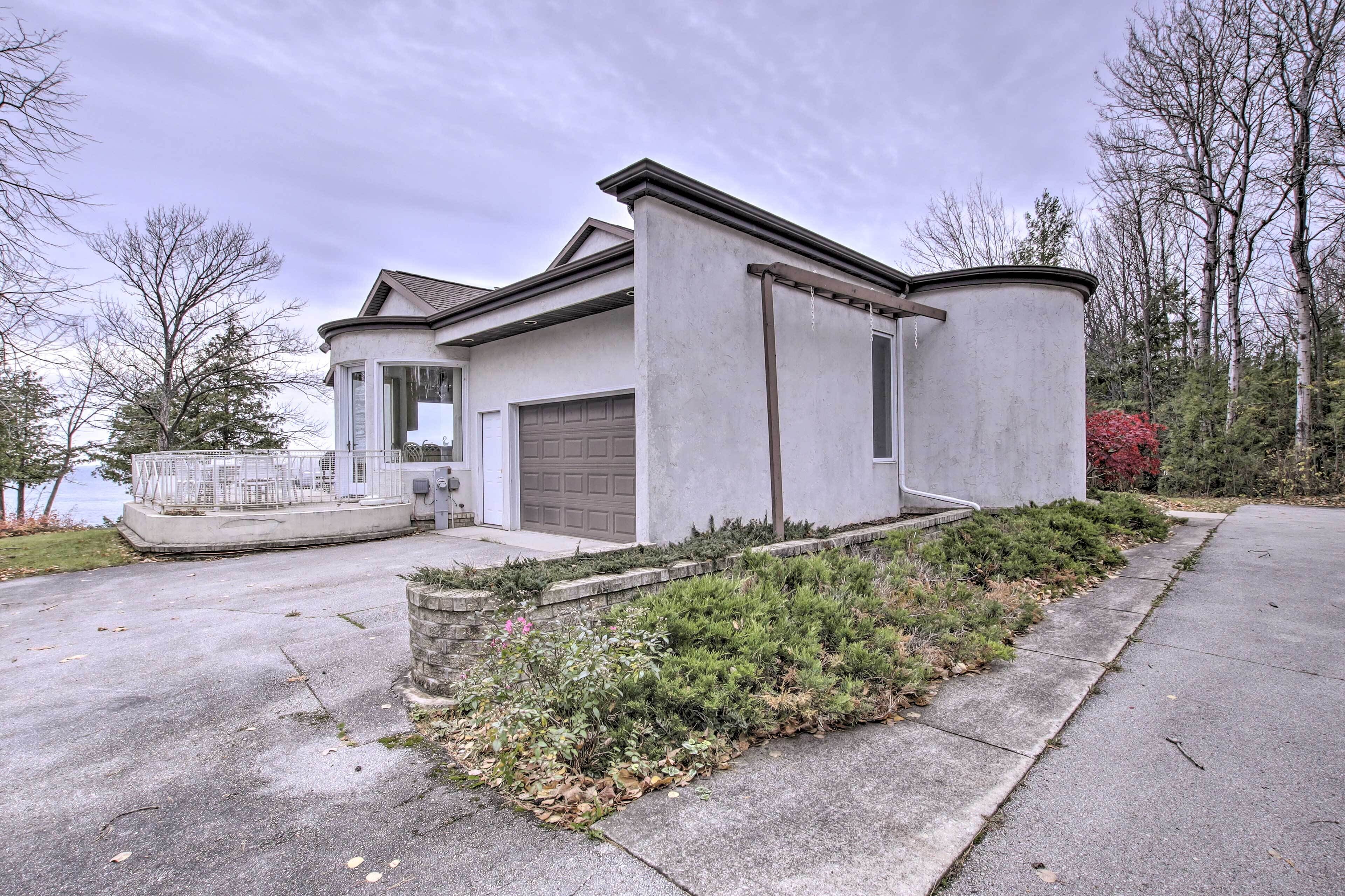 A modern two-story house with a garage, a covered porch, and a landscaped front yard.