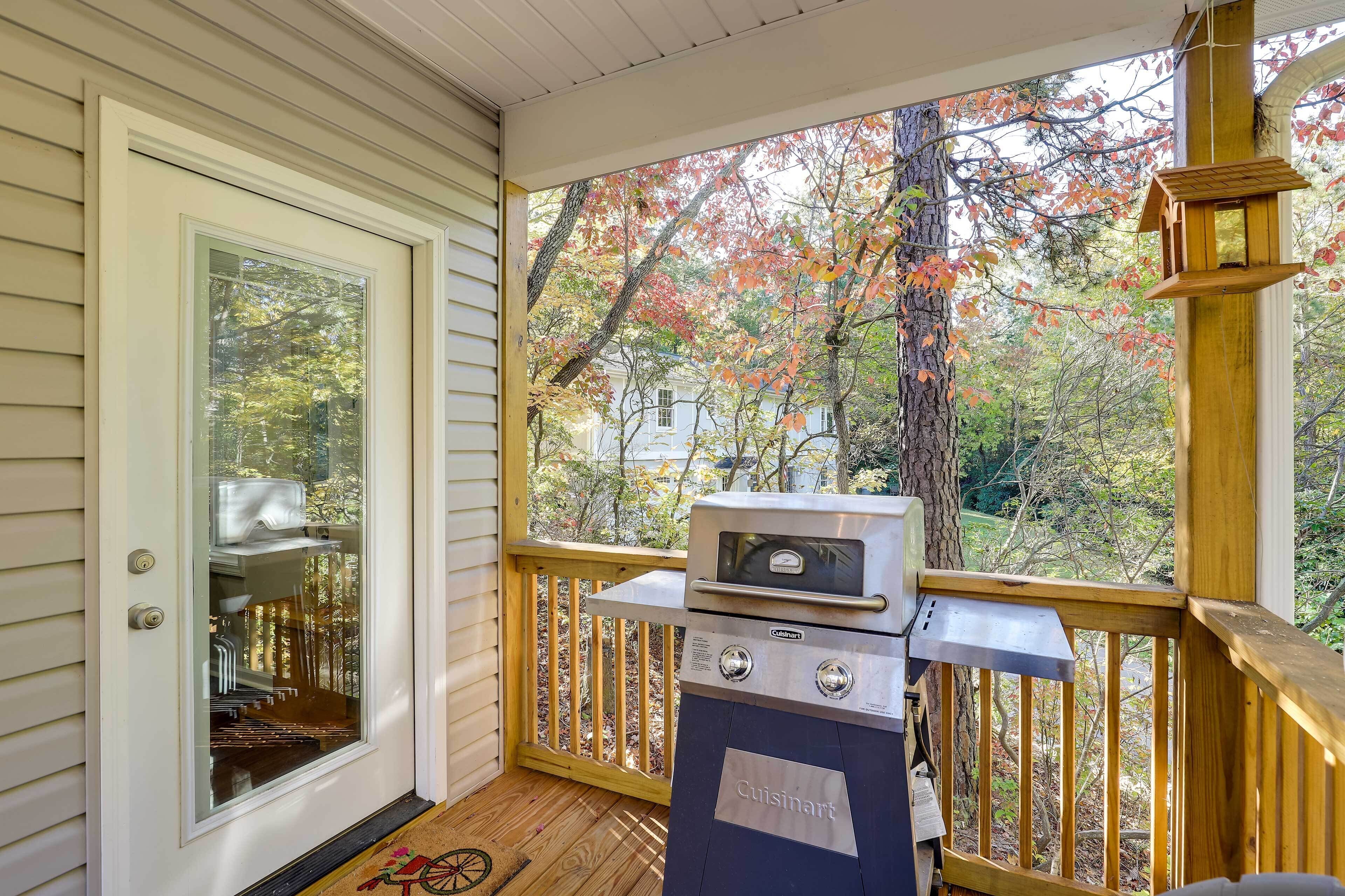 A porch with a grill and a door.