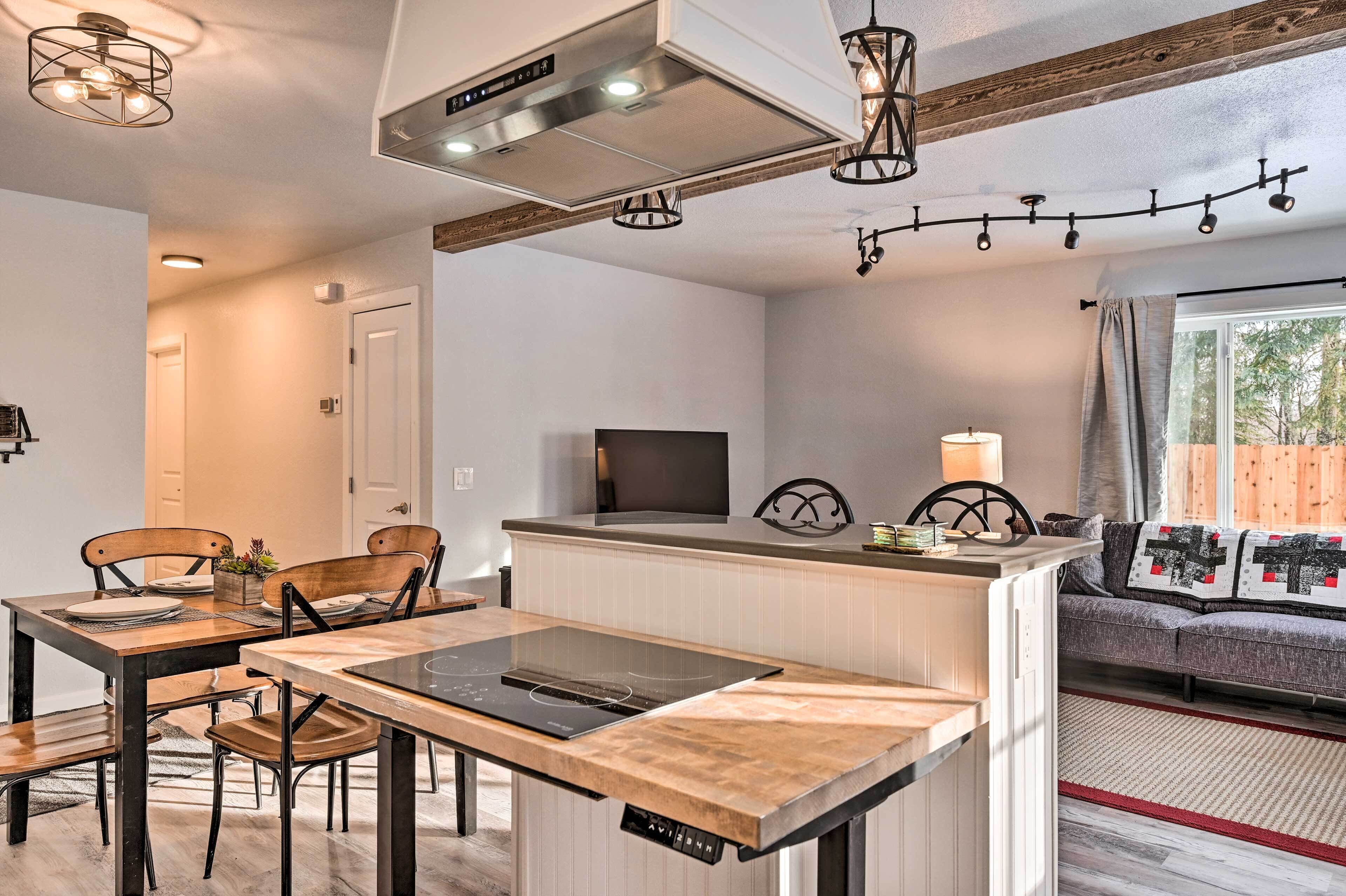 Une cuisine compacte avec un îlot central, une table à manger avec des chaises, un canapé et un téléviseur.