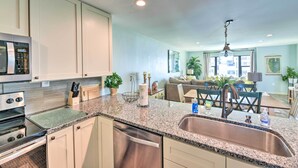 A modern kitchen with granite countertops, stainless steel appliances, and a central island. - Summer Winds Resort Condo w/ Ocean Views! (Atlantic Beach)