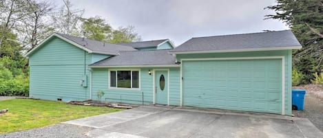 Ein eingeschossiges Haus mit Garage, Veranda und kleinem Vorgarten.