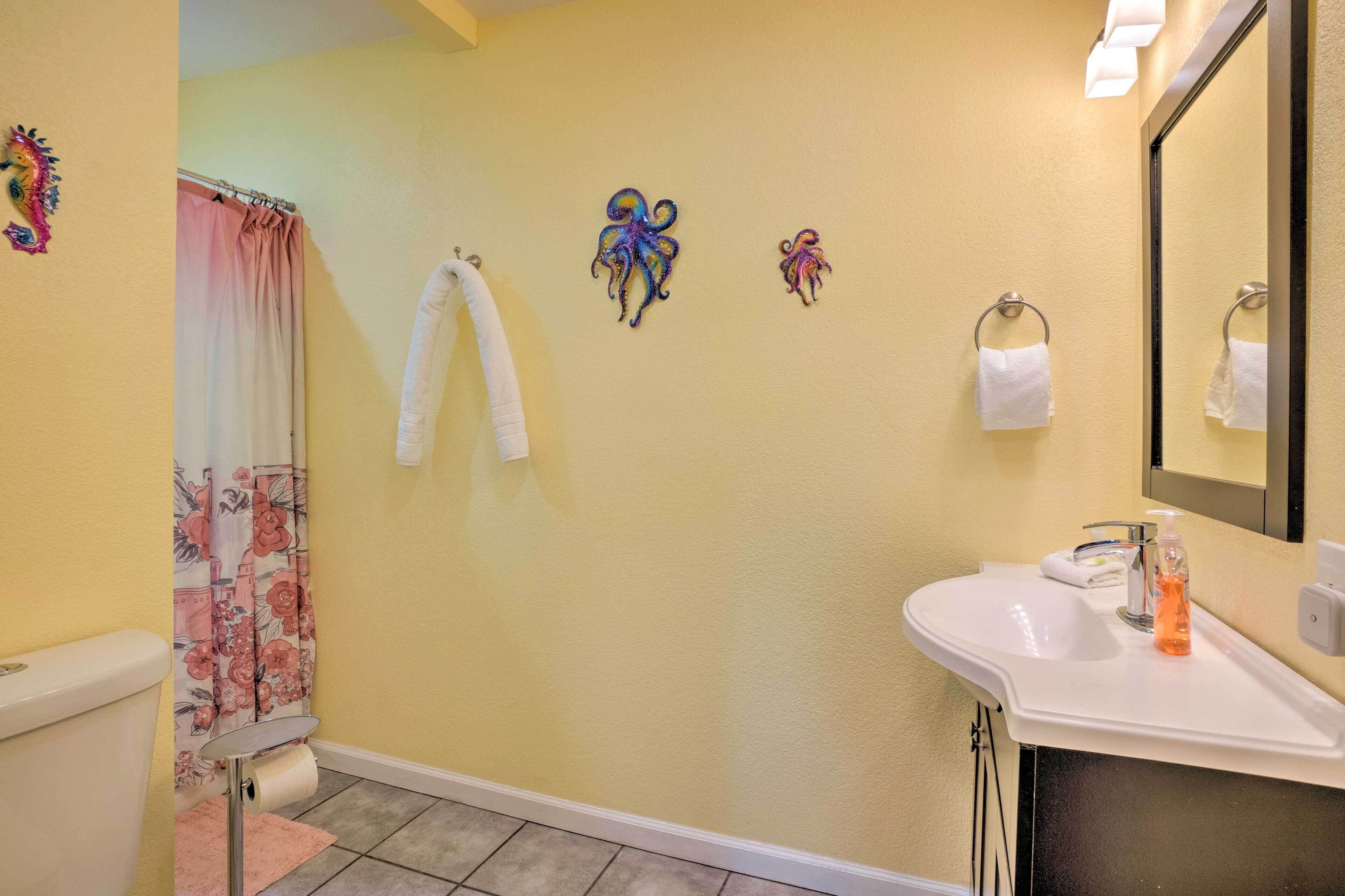 Un baño con inodoro, lavamanos, espejo y cortina de ducha.