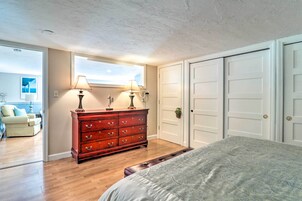 Un dormitorio con cama, cómoda, ventana y puerta.