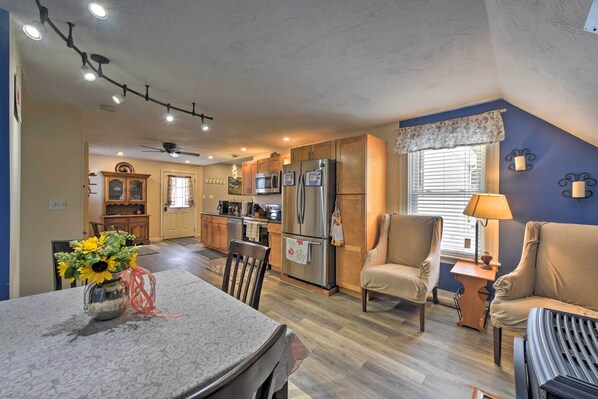 A spacious kitchen with modern appliances, a dining area with a table and chairs, and a cozy seating area with a sofa and armchairs.