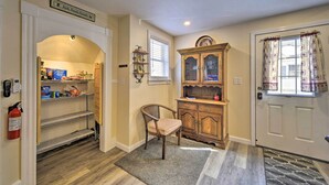 A hallway with a wooden chair, a cabinet, and a fire extinguisher.
