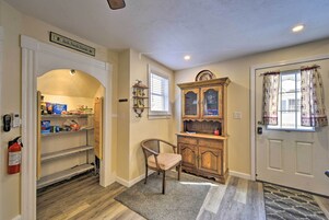 A hallway with a wooden chair, a cabinet, and a fire extinguisher.