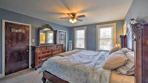 A bedroom with a bed, dresser, and ceiling fan.