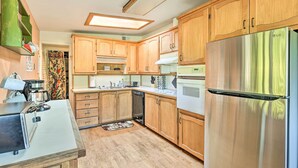A kitchen with wooden cabinets, a stainless steel refrigerator, a coffee machine, and a microwave. - Pet-friendly Eureka Home ~ 6 Mi to Old Town! (Eureka)