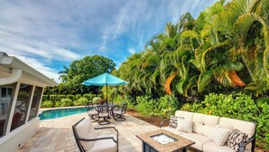 A patio with a pool, outdoor furniture, and lush greenery. - Lush Punta Gorda Escape: Private Pool + Lanai (Punta Gorda)