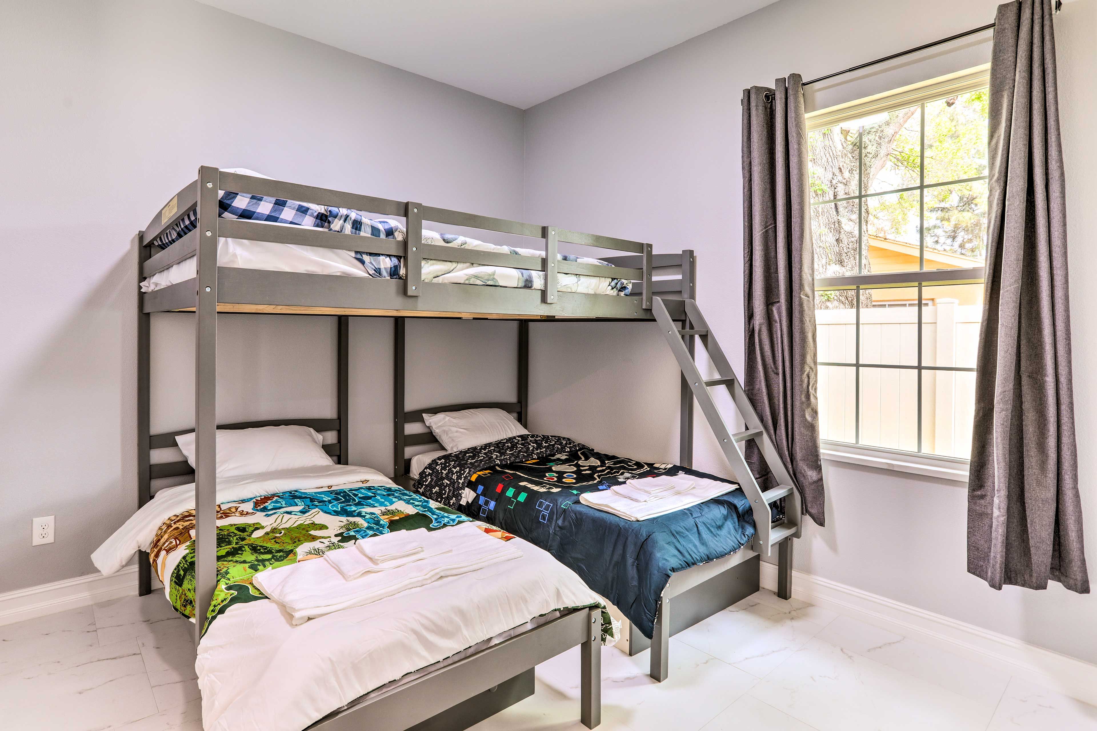 A bunk bed room with a window and curtains.