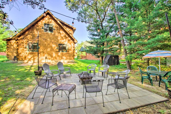 Relax in a cozy cabin with a patio area featuring a fire pit and comfortable seating.