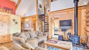 A cozy living room with a sofa, a coffee table, and a fireplace. - Mountain Views & Fire Pit: Granby Retreat! (Granby)