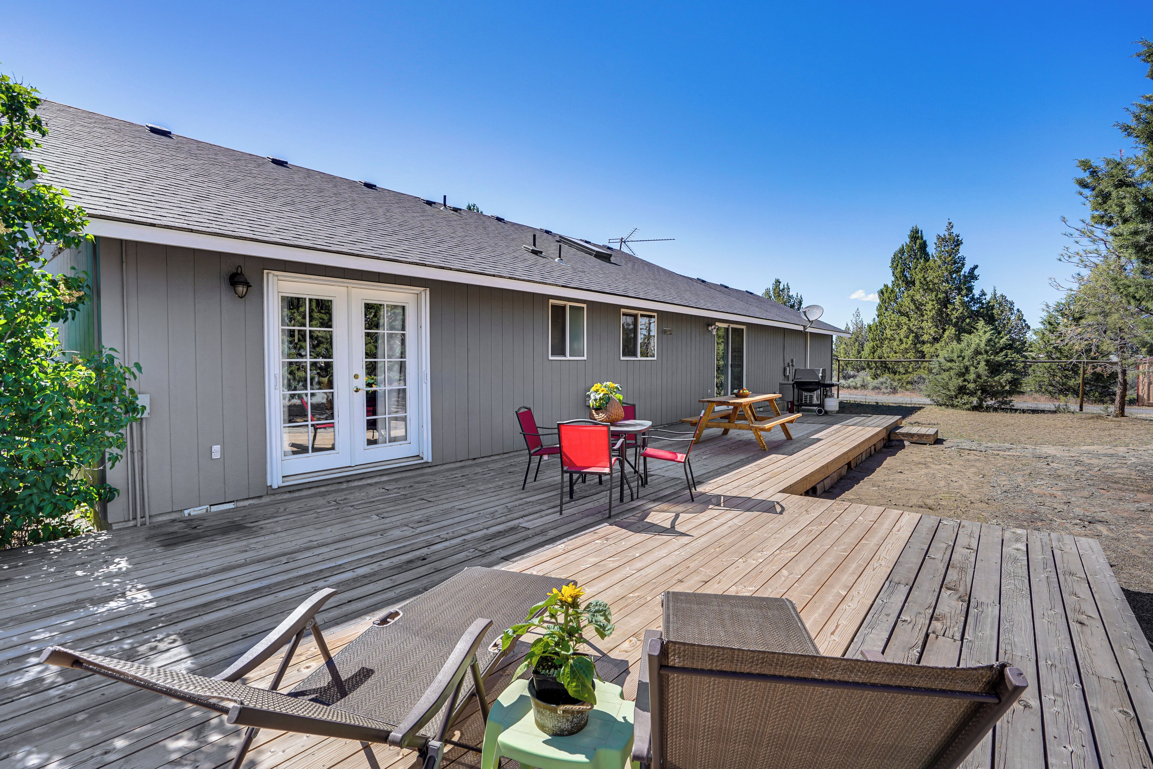 A deck with outdoor furniture, a barbecue grill, and a covered patio area.