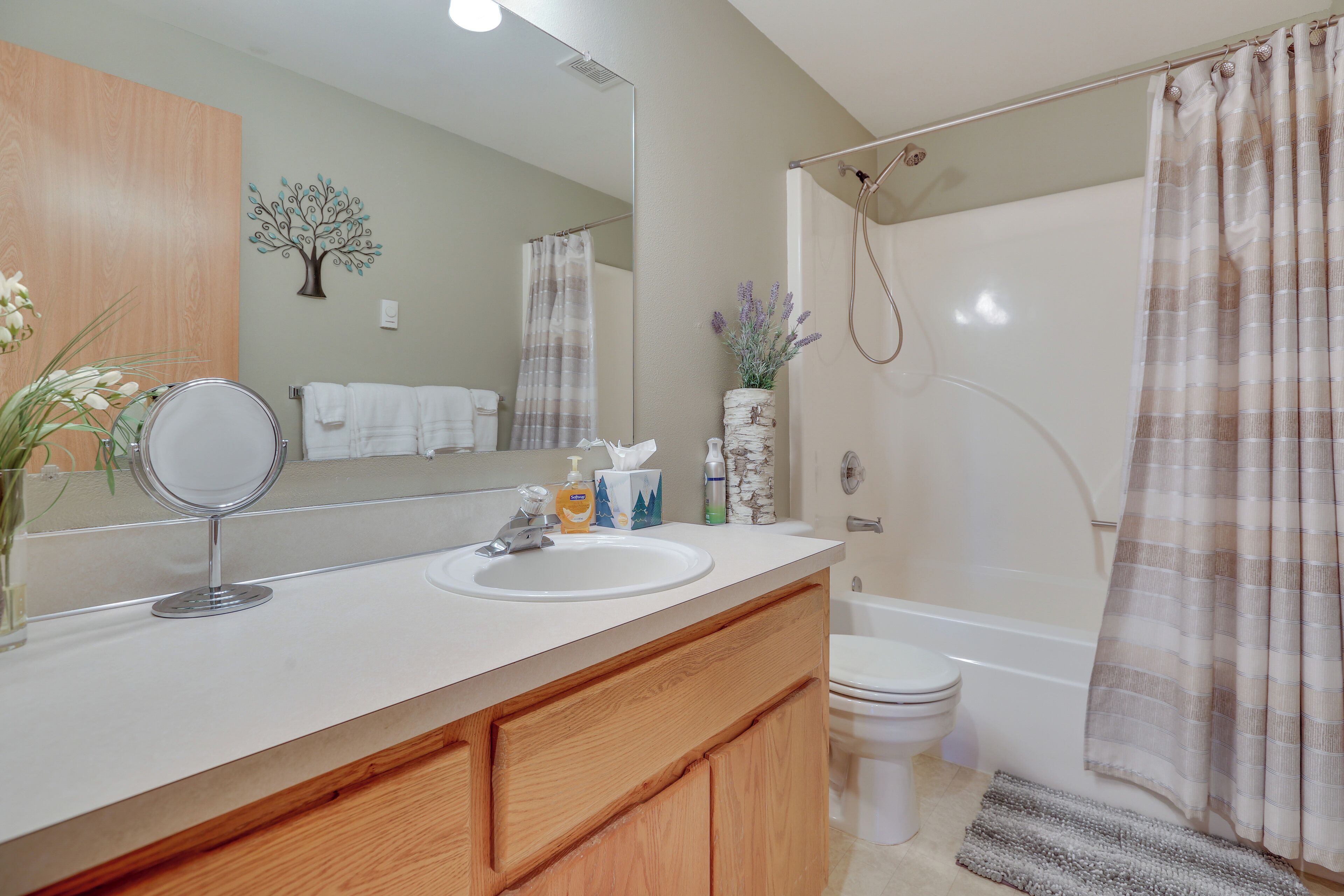 A bathroom with a sink, mirror, and a shower curtain.