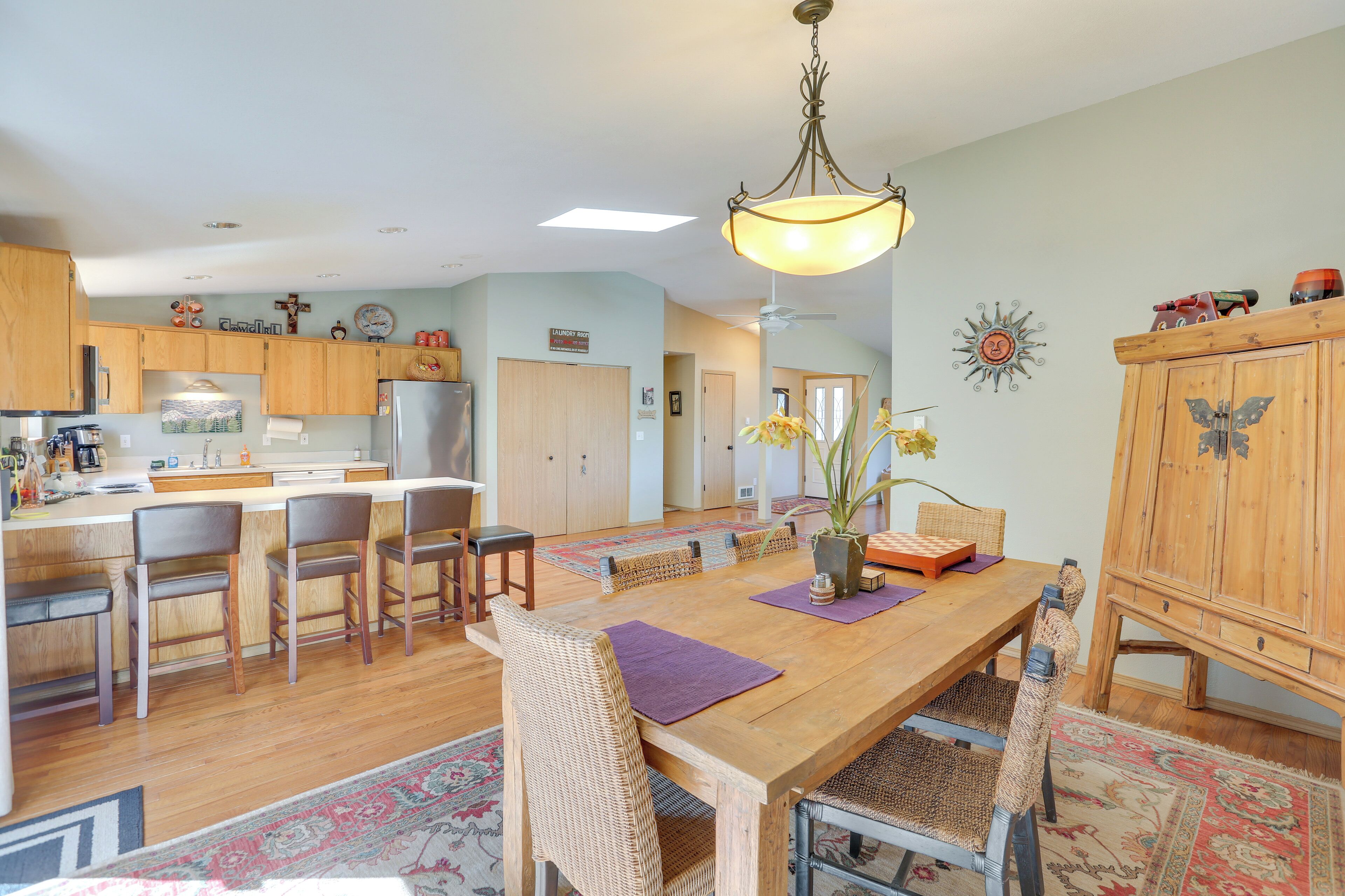 A spacious kitchen with wooden cabinets, a central island, and bar stools.