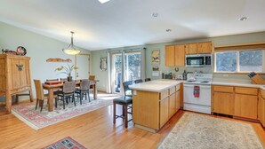 Eine geräumige Küche mit Holdekor, einer zentralen Kochinsel und einem Essbereich mit Tisch und Stühlen.