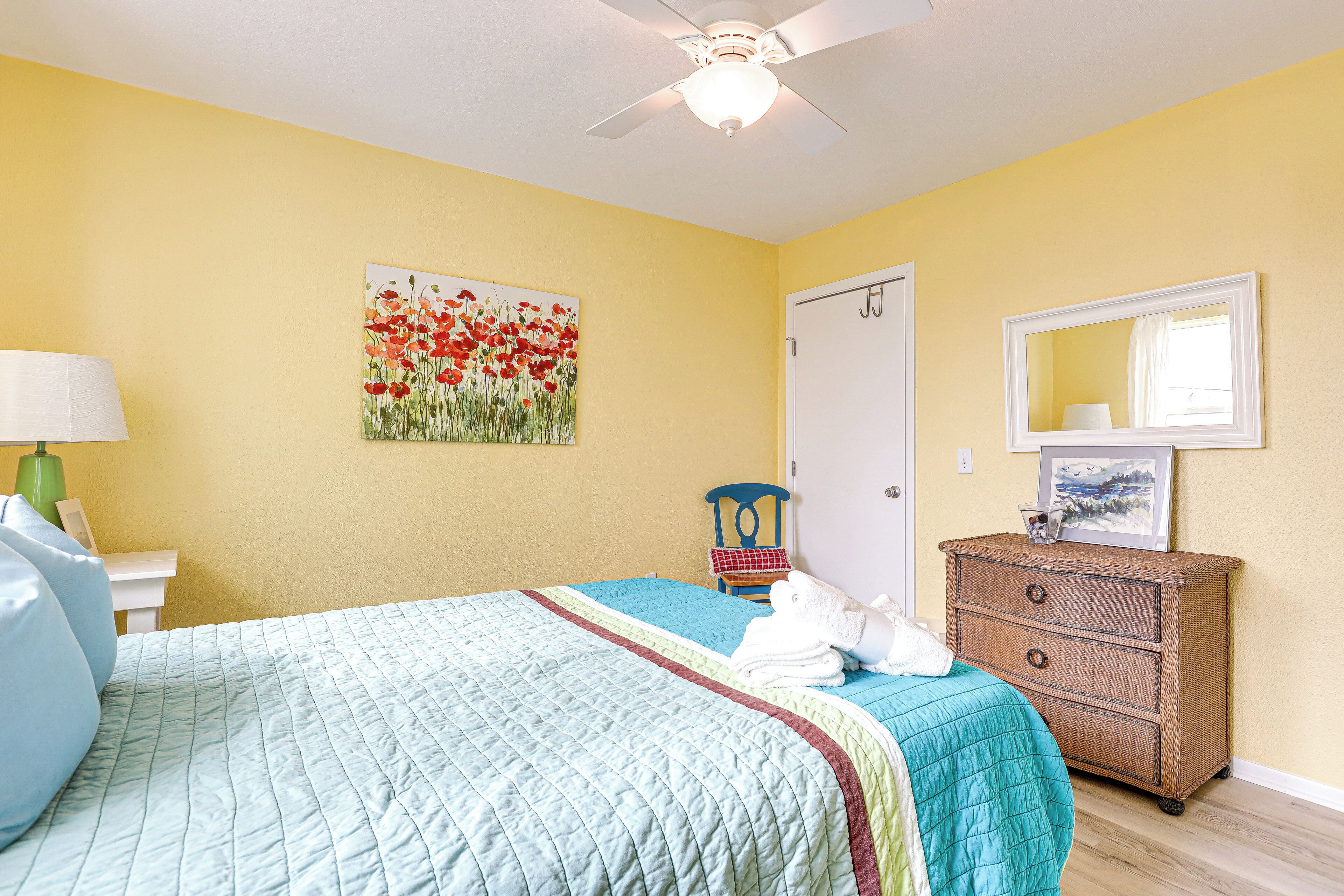 A bedroom with a bed, a dresser, a chair, and a painting on the wall.