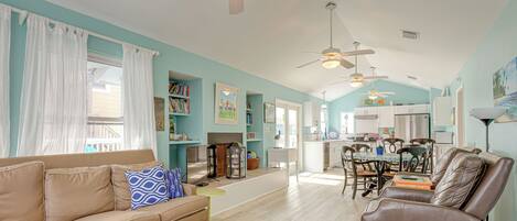 A spacious living room with a sofa, a coffee table, and a dining area with chairs and a table.