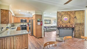 A spacious kitchen with wooden cabinets, a central island, and a dining area with a table and chairs. - Charming Shasta Lake Retreat: Boat, Hike & Fish! (Lakehead)