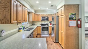 A modern kitchen with wooden cabinets, stainless steel appliances, and a granite countertop. - Charming Shasta Lake Retreat: Boat, Hike & Fish! (Lakehead)