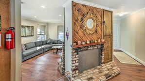 A living room with a fireplace, a sectional sofa, and a wooden accent wall. - Charming Shasta Lake Retreat: Boat, Hike & Fish! (Lakehead)
