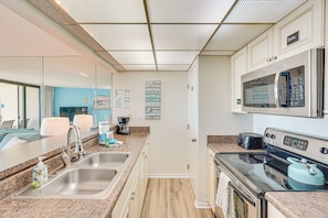 A modern kitchen with stainless steel appliances, a double sink, and a microwave. - PCB Vacation Rental w/ Sweeping Ocean Views! (Panama City Beach)