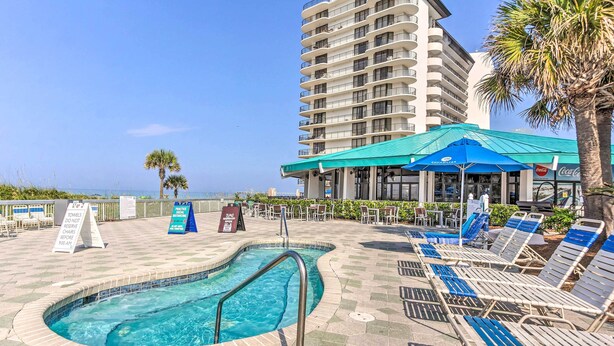 A pool area with lounge chairs and a sign indicating towel and chair reservation policies. - PCB Vacation Rental w/ Sweeping Ocean Views! (Panama City Beach)
