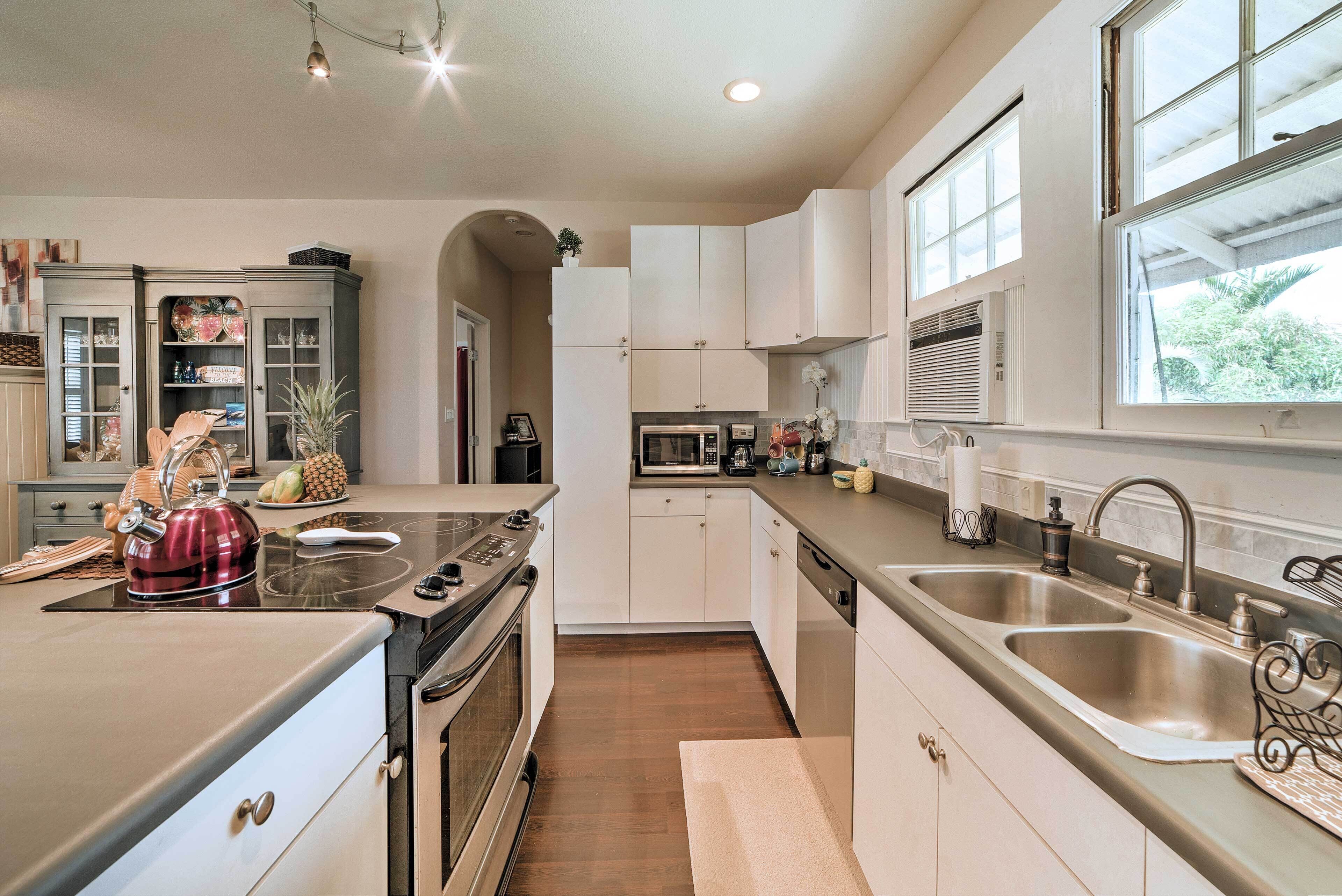 A modern kitchen with a stove, microwave, and double sink.