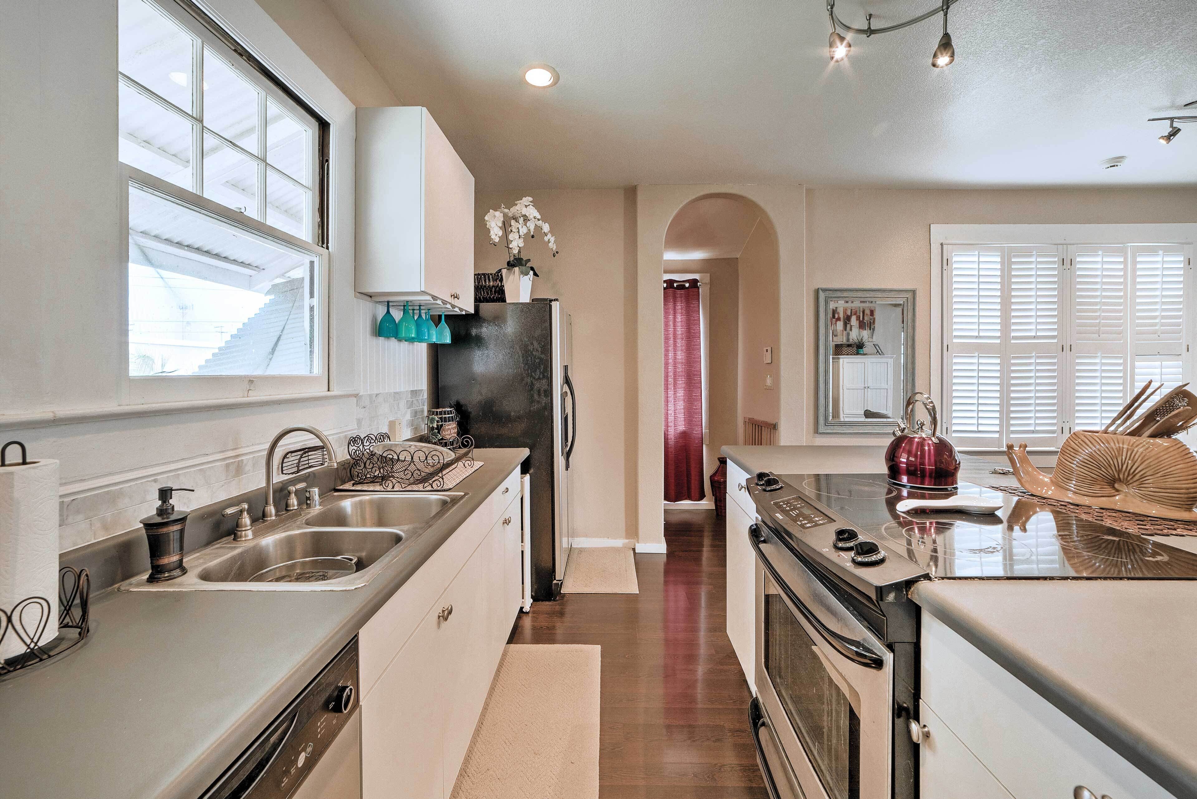 A modern kitchen with stainless steel appliances, a large window, and a view of the backyard.