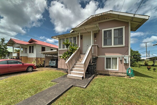 A two-story house with a front porch, a staircase, and a red car parked in the driveway. - Hawaiian Hideaway w/ Yard < 2 Miles to Hilo Bay! (Hilo)