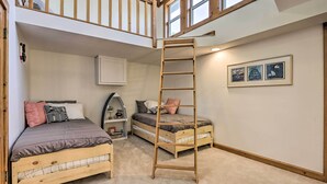 A loft bedroom with two wooden beds, a ladder, a white cabinet, and a lofted window. - Sunny 'providence Cottage' Retreat w/ Dock, Kayaks (Sunrise Beach)
