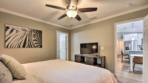 A bedroom with a large bed, a ceiling fan, a television, and a zebra print artwork on the wall. - Serene Live Oak Home w/ Fire Pit by River + Sosmp! (Live Oak)
