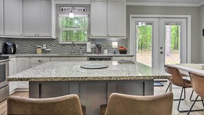 A kitchen with white cabinets, a granite countertop, and a sign reading "BLUE POT CAFE". - Serene Live Oak Home w/ Fire Pit by River + Sosmp! (Live Oak)