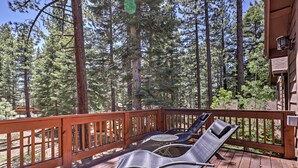 A wooden deck with two lounge chairs and a table, surrounded by tall pine trees. - Close to Slopes: Forest-view Gem in Lake Tahoe (South Lake Tahoe)