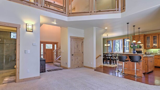 A spacious multi-level home interior with a kitchen, dining area, and a staircase leading to an upper level. - Close to Slopes: Forest-view Gem in Lake Tahoe (South Lake Tahoe)