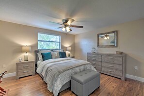 A bedroom with a bed, nightstands, a dresser, a ceiling fan, a window, and a mirror. - Canalfront Home w/ Dock & Access to Gulf of Mexico (Hudson)