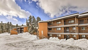 A multi-story hotel with wooden exterior walls, balconies, and a snowy landscape. - Gorgeous Winter Park Condo w/ Private Deck! (Winter Park)