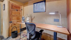A wooden desk with a chair, a lamp, and a small vase with flowers. - Adobe Studio: 2 Blocks to Dtwn Santa Fe Plaza! (Santa Fe)