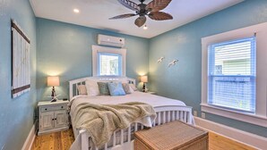 A bedroom with a bed, nightstands, a ceiling fan, and a window. - Bright Bradenton Retreat: 1 Mi to Downtown! (Bradenton)