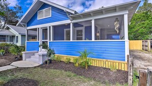 A two-story house with a blue exterior and white trim, featuring a front porch and a visible staircase leading to the entrance. - Bright Bradenton Retreat: 1 Mi to Downtown! (Bradenton)